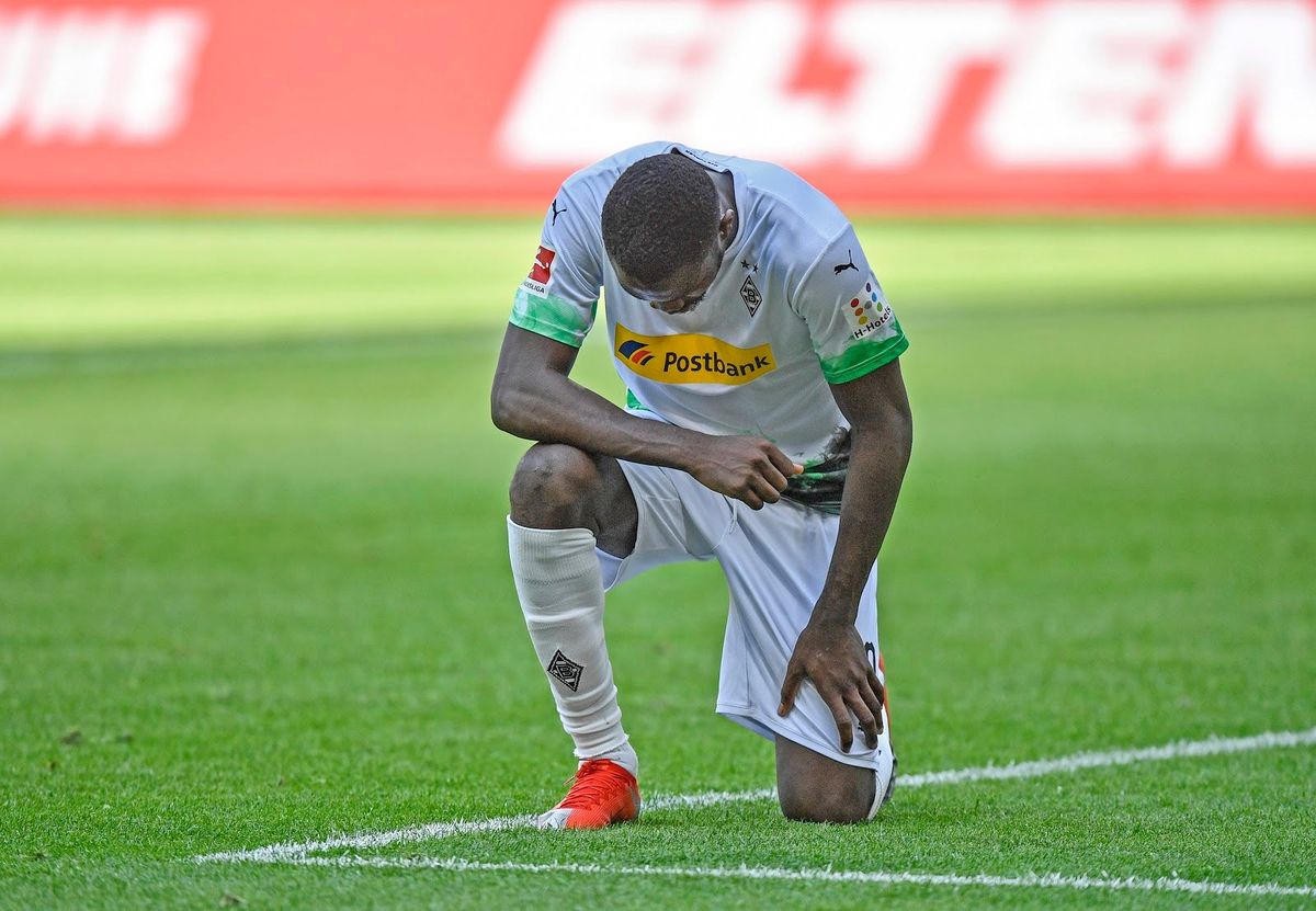 Monchenbladbach’s Marcus Thuram takes a knee after scoring a goal Sunday.