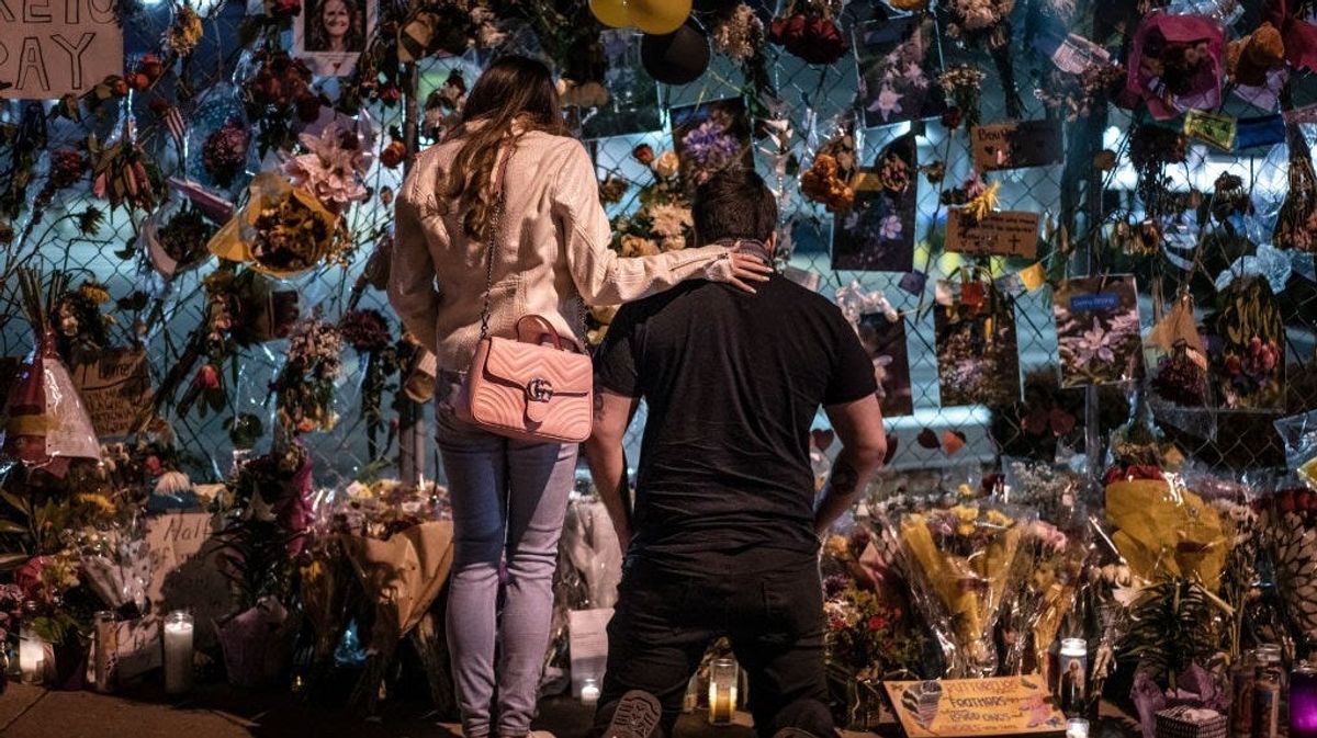 Mourners visit a memorial to those lost in a shooting at a King Soopers grocery store earlier in the week on March 27, 2021 in Boulder, Colorado. The shooting at the King Soopers Grocery on Monday left ten people dead, including one police officer.