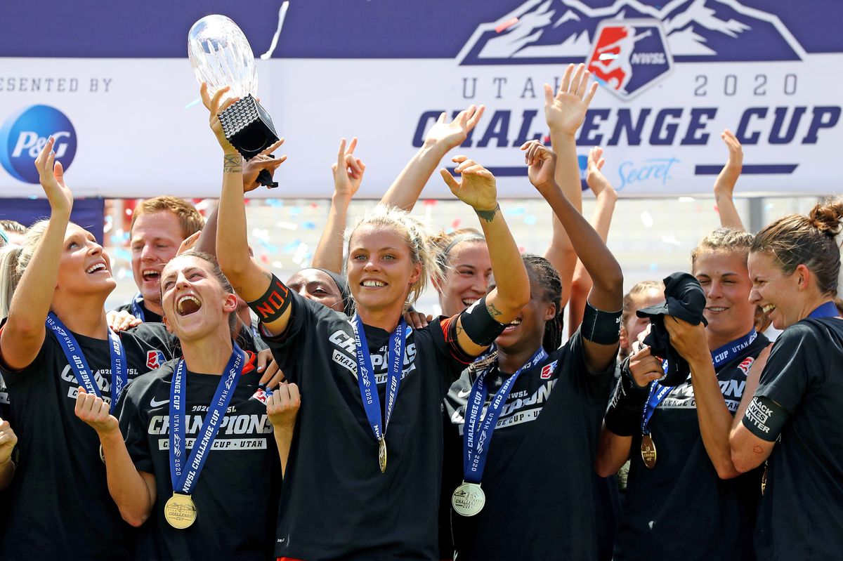 Rachel Daly of Houston Dash hoists trophy with her teammates after defeating the Chicago Red Stars to win the championship game of the NWSL Challenge Cup at Rio Tinto Stadium.