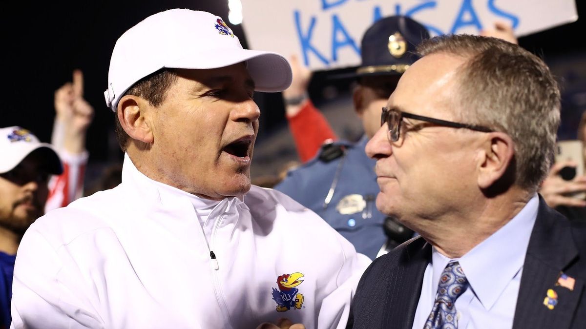 Former Kansas AD Jeff Long probably wishes this picture of him gazing longlingly into Les Miles‘ eyes didn’t exist right about now.