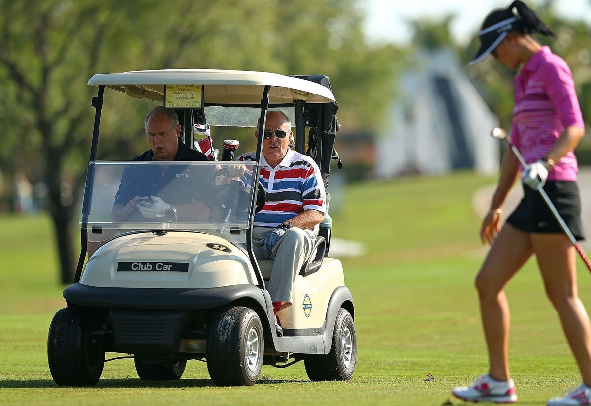 Stupid fucking toad-man Rush Limbaugh sits shotgun as stupid fucking toad-man Rudolph Giuliani gawks at Michelle Wie in 2014..