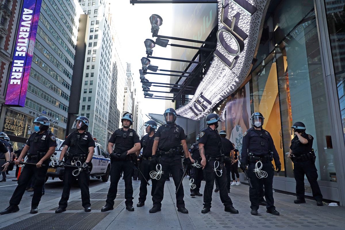 NYPD cops line up in Times Square Saturday night before clashing with protesters.