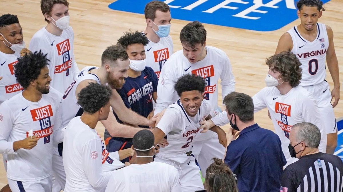 Teammates mob Virginia’s Reece Beekman after his buzzer  beater over Syracuse.