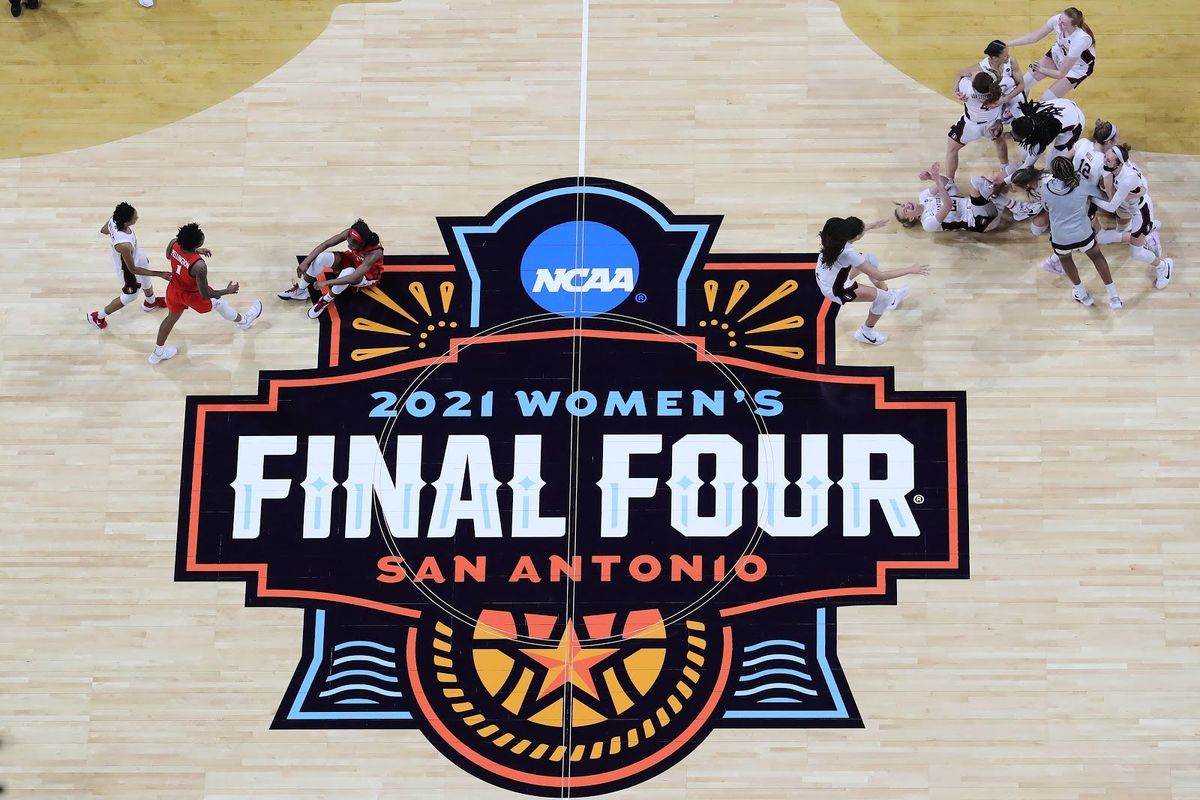 Stanford celebrates their victory while a dejected Aari McDonald of Arizona sits on the court after the Cardinals won the women’s national championship on Sunday.