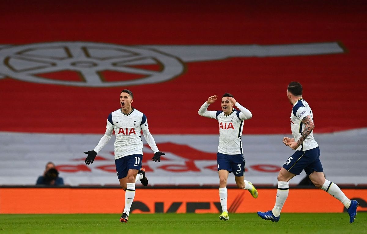 Erik Lamela (L) celebrates scoring the opening goal during the English Premier League football match between Arsenal and Tottenham Hotspur at the Emirates Stadium in London