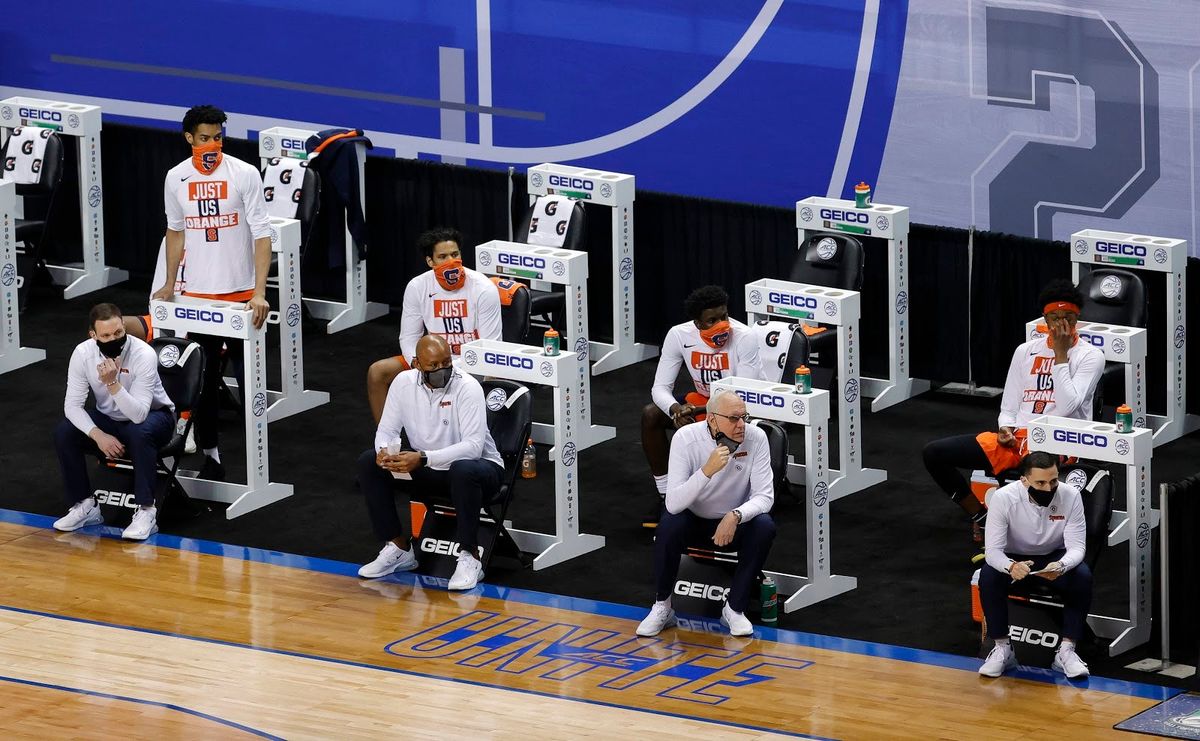 Syracuse looks on with masks up and down in their game against Virginia in ACC T ournament .