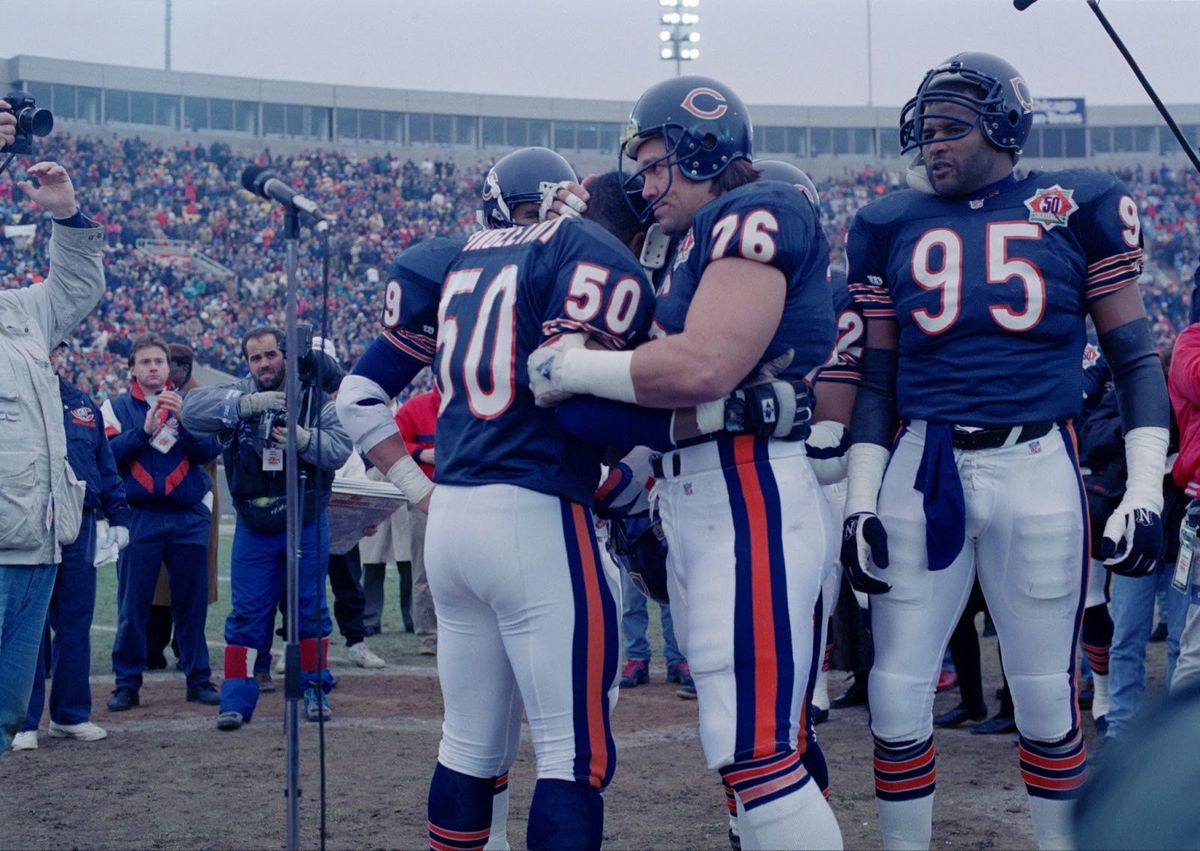 Mike Singletary (50) gets a bear hug from teammate Steve McMichael prior to the game against the Pittsburgh Steelers in Chicago, Dec. 13, 1992.