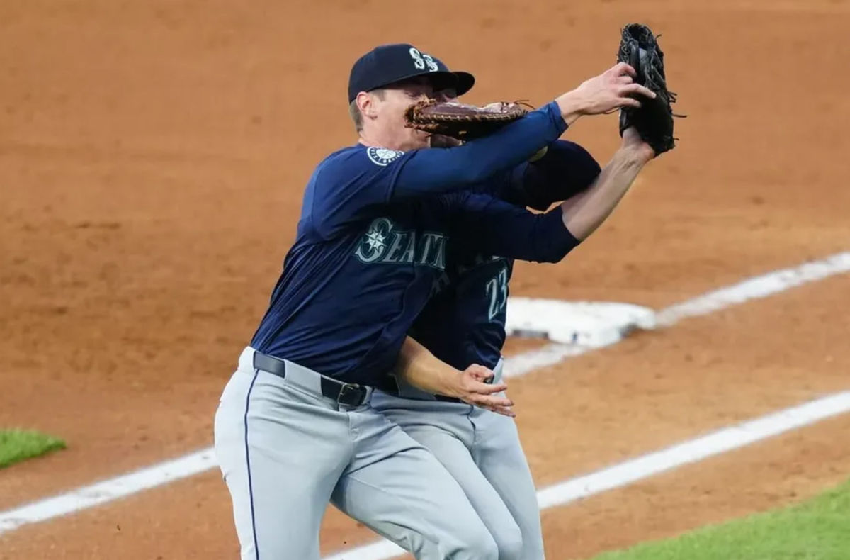 Apr 21, 2024; Denver, Colorado, USA; Seattle Mariners starting pitcher Emerson Hancock (62) and first base Ty France (23) collide fielding a pop fly in the fourth inning against the Colorado Rockies at Coors Field. credits: Ron Chenoy-USA TODAY Sports