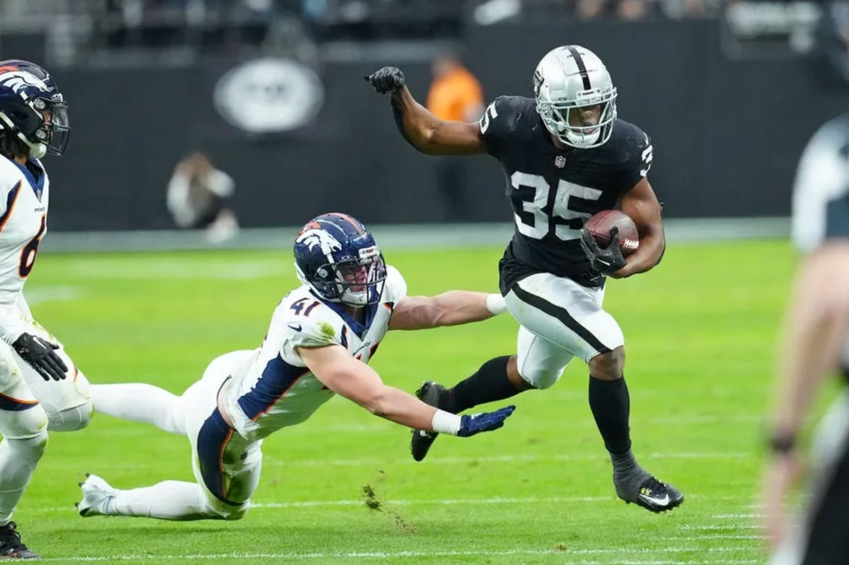 7 de enero de 2024; Paraíso, Nevada, EE.UU.; Las Vegas Raiders corriendo detrás Zamir White (35) es empujado fuera de los límites por el linebacker de Denver Broncos Drew Sanders (41) durante el segundo cuarto en el estadio Allegiant. Crédito obligatorio: Stephen R. Sylvanie-USA TODAY Deportes