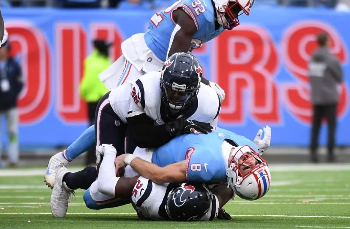 17 de diciembre de 2023; Nashville, Tennessee, Estados Unidos; El mariscal de campo de los Tennessee Titans, Will Levis (8), está herido después de ser saqueado por el cornerback de los Houston Texans, Desmond King II (25), el tackle defensivo Sheldon Rankins (98) en tiempo extra en el Estadio Nissan. Créditos: Christopher Hanewinckel-USA TODAY Deportes