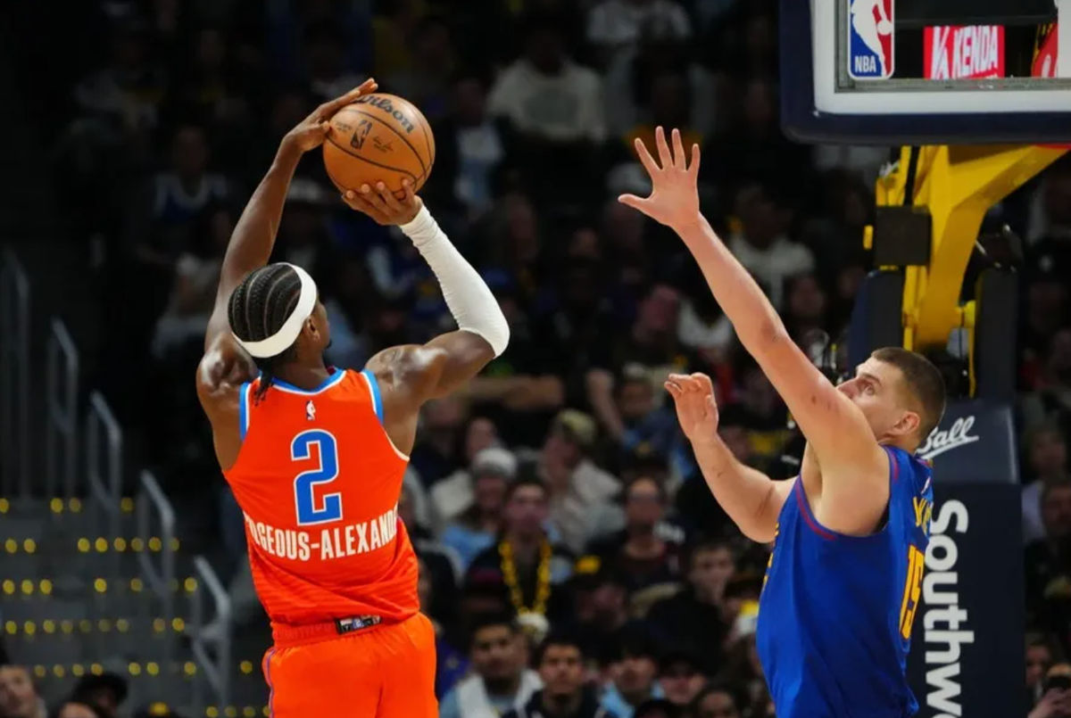 16 de dezembro de 2023; Denver, Colorado, EUA; O armador do Oklahoma City Thunder, Shai Gilgeous-Alexander (2), chuta a bola sobre o pivô do Denver Nuggets, Nikola Jokic (15), no quarto período na Ball Arena. Crédito obrigatório: Ron Chenoy-USA TODAY Sports