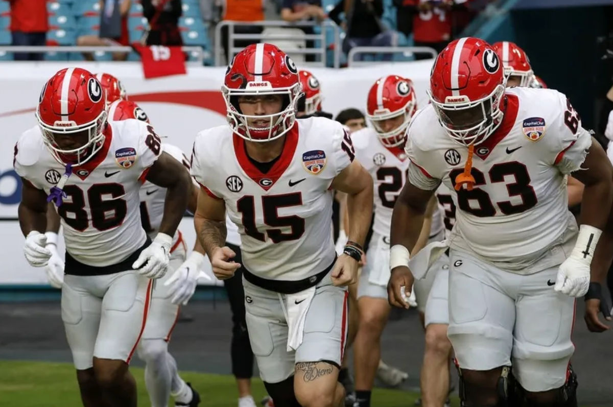 30 de dezembro de 2023; Miami Gardens, Flórida, EUA; O quarterback do Georgia Bulldogs, Carson Beck (15), lidera o time em campo antes do jogo contra o Florida State Seminoles pelo Orange Bowl de 2023 no Hard Rock Stadium. créditos: Sam Navarro-USA TODAY Sports