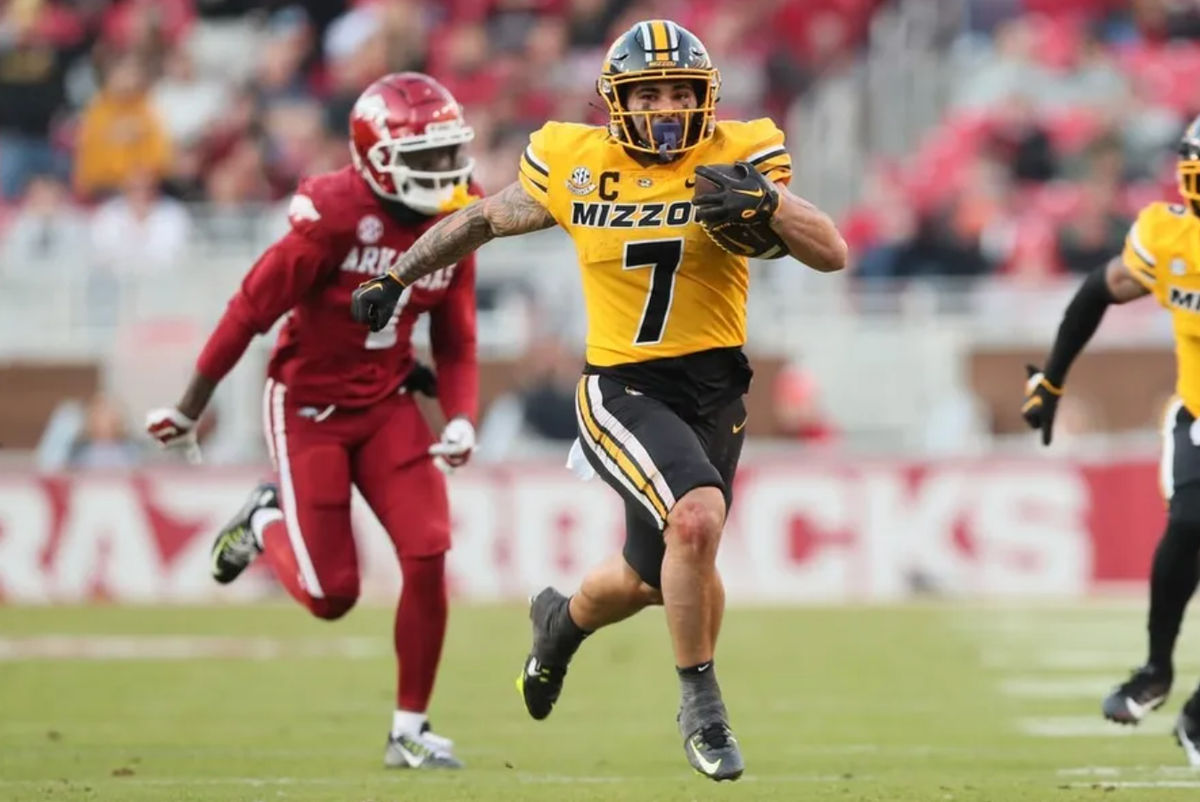 24 de novembro de 2023; Fayetteville, Arkansas, EUA; O running back do Missouri Tigers, Cody Schrader (7), corre contra o Arkansas Razorbacks durante o segundo quarto no Donald W. Reynolds Razorback Stadium. créditos: Nelson Chenault-USA TODAY Sports