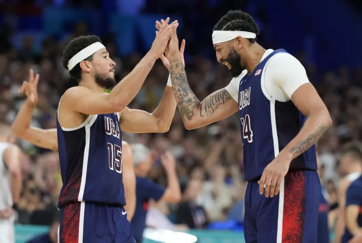 O guarda dos Estados Unidos Devin Booker (15) e o pivô Anthony Davis (14) comemoram no quarto período contra a Sérvia durante os Jogos Olímpicos de Verão de Paris 2024, no Stade Pierre-Mauroy. Crédito obrigatório: John David Mercer-USA TODAY Sports