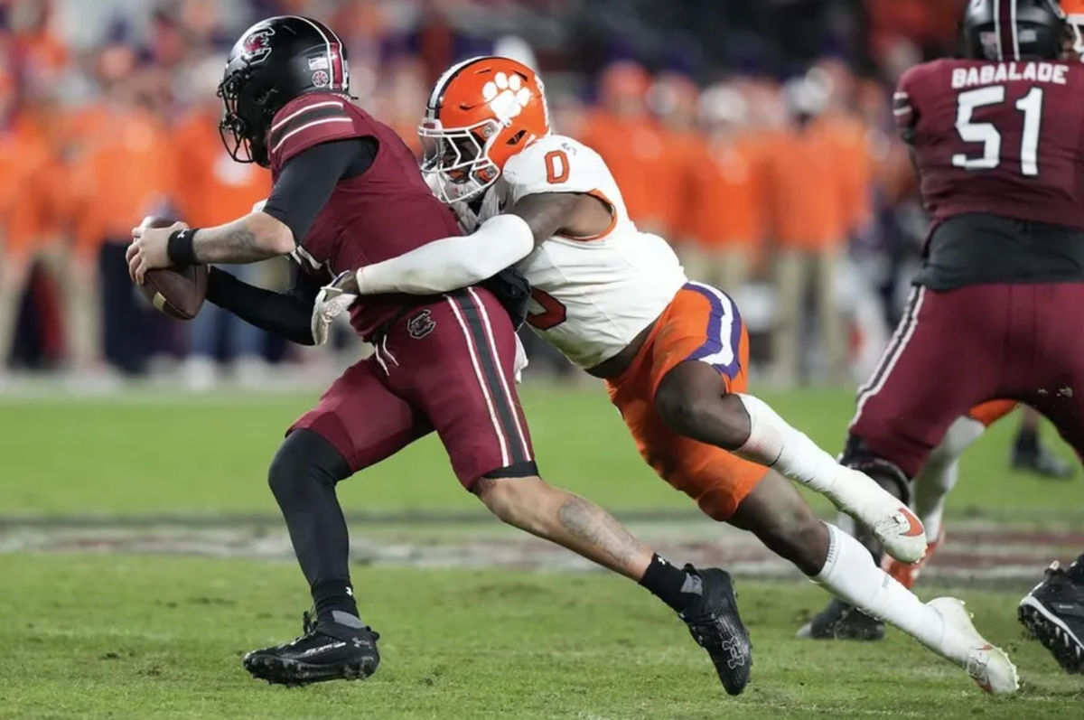 25 de noviembre de 2023; Columbia, Carolina del Sur, EE. UU.; El mariscal de campo de los South Carolina Gamecocks, Spencer Rattler (7), es capturado por el apoyador de los Clemson Tigers, Barrett Carter (0), en la primera mitad en el Williams-Brice Stadium. Créditos: David Yeazell-USA TODAY Sports