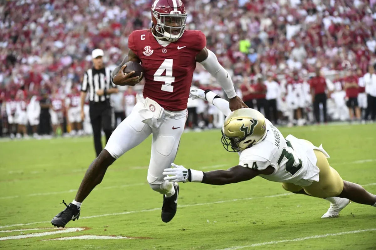 7 de setembro de 2024; Tuscaloosa, Alabama, EUA; O quarterback do Alabama Crimson Tide, Jalen Milroe (4), corre para um touchdown contra o jogador de linha defensiva do South Florida Bulls, Rico Watson III (34), no Bryant-Denny Stadium. Crédito obrigatório: Gary Cosby Jr.-Imagn Images