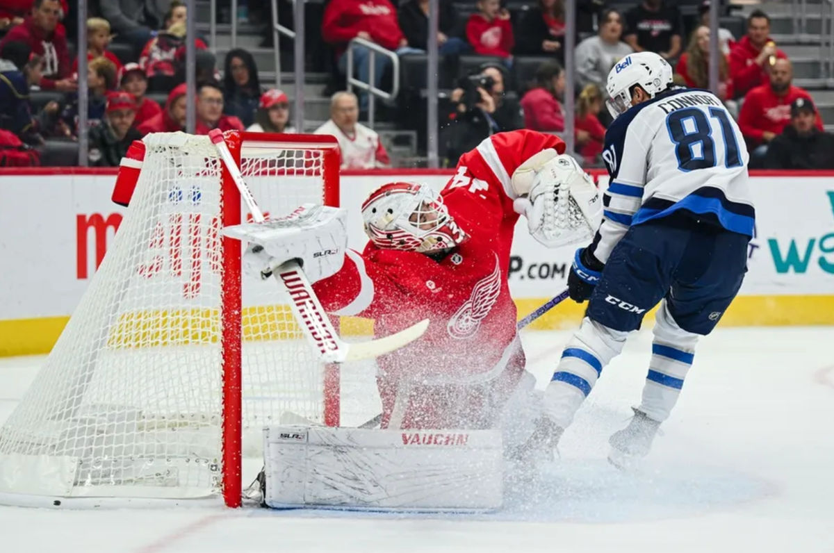30 de outubro de 2024; Detroit, Michigan, EUA; O ala esquerdo do Winnipeg Jets, Kyle Connor (81), marca um gol enquanto o goleiro do Detroit Red Wings, Alex Lyon (34), cuida da rede durante o primeiro período na Little Caesars Arena. Crédito obrigatório: Tim Fuller-Imagn Images