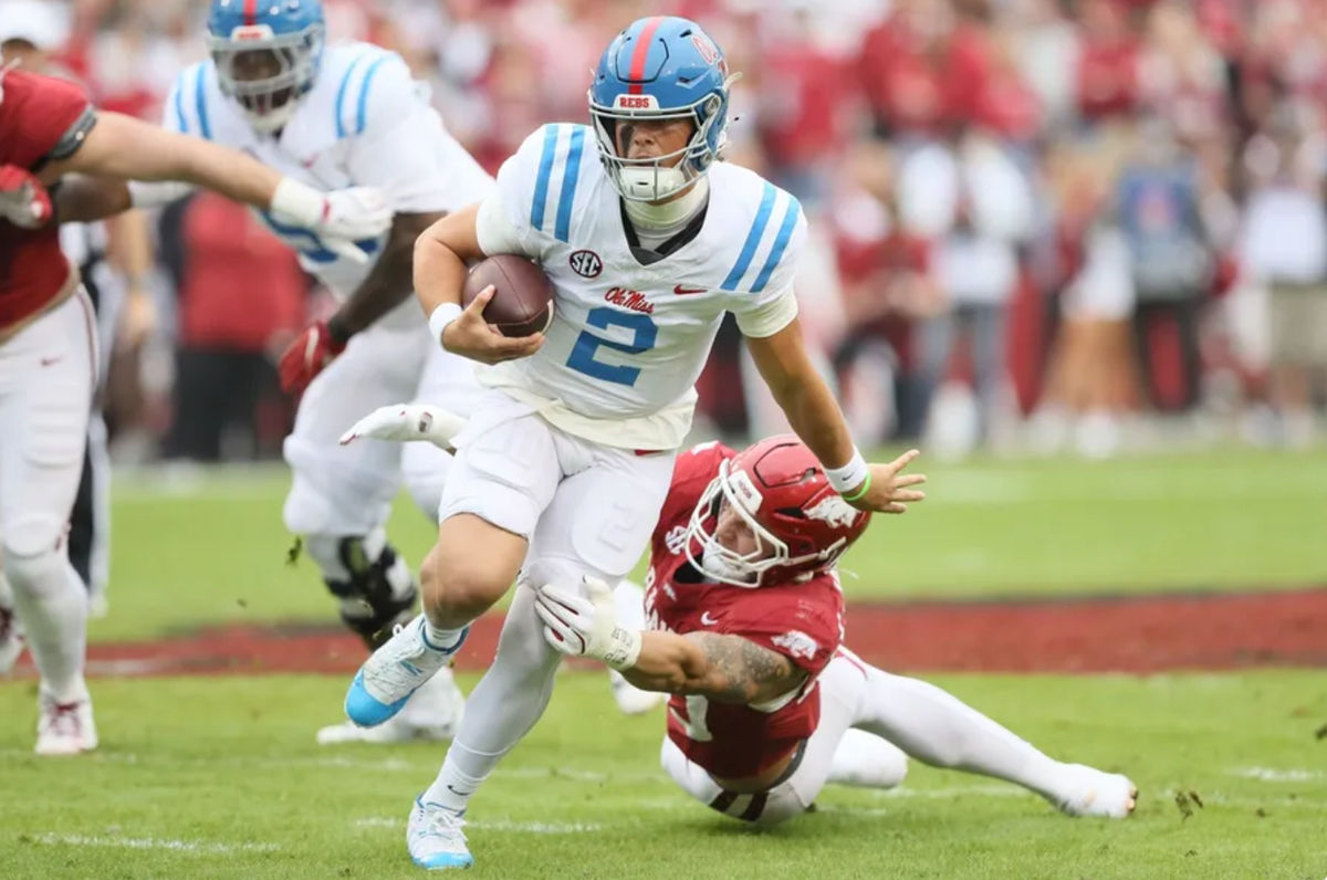 2 de novembro de 2024; Fayetteville, Arkansas, EUA; O quarterback do Ole Miss Rebels, Jaxson Dart (2), corre no primeiro quarto contra o Arkansas Razorbacks no Donald W. Reynolds Razorback Stadium. Crédito obrigatório: Nelson Chenault-Imagn Images