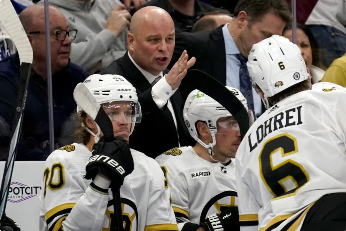Mar 4, 2024; Toronto, Ontario, CAN; Boston Bruins head coach Jim Montgomery talks to defenseman Mason Lohrei (6) during a break in the action against the Toronto Maple Leafs during the second period at Scotiabank Arena. Mandatory Credit: John E. Sokolowski-Imagn Images