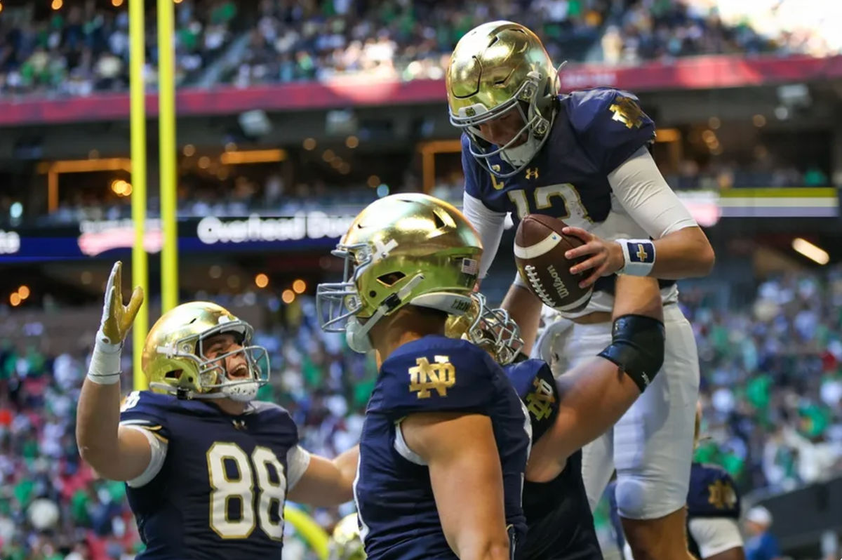 O quarterback do Notre Dame Fighting Irish, Riley Leonard (13), comemora com os companheiros de equipe após um touchdown contra o Georgia Tech Yellow Jackets no segundo quarto no Mercedes-Benz Stadium. Crédito obrigatório: Brett Davis-Imagn Images