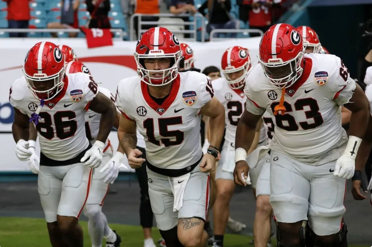 30 de dezembro de 2023; Miami Gardens, FL, EUA; O quarterback do Georgia Bulldogs, Carson Beck (15), lidera o time em campo antes do jogo contra o Florida State Seminoles para o Orange Bowl de 2023 no Hard Rock Stadium. créditos: Sam Navarro-USA TODAY Sports