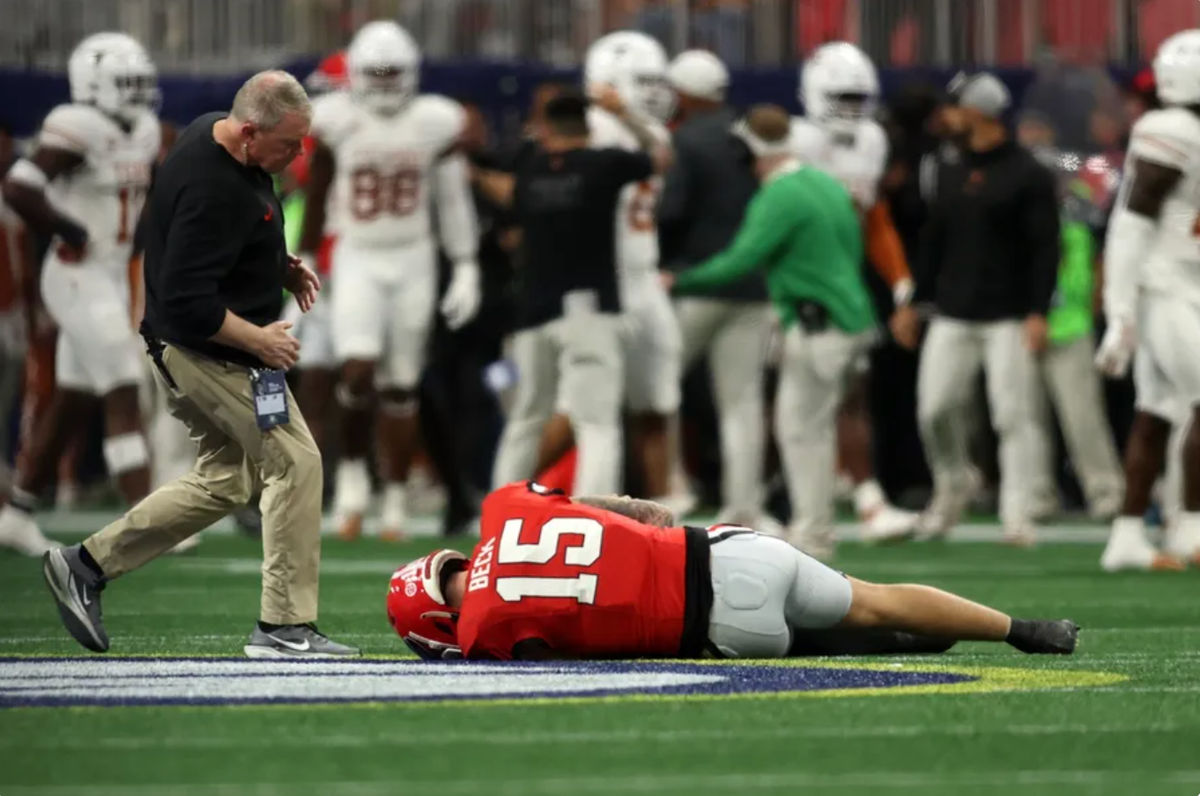 7 de dezembro de 2024; Atlanta, GA, EUA; O quarterback do Georgia Bulldogs, Carson Beck (15), se machuca em uma jogada contra o Texas Longhorns durante o primeiro tempo do jogo do Campeonato SEC de 2024 no Mercedes-Benz Stadium. Crédito obrigatório: Brett Davis-Imagn Images