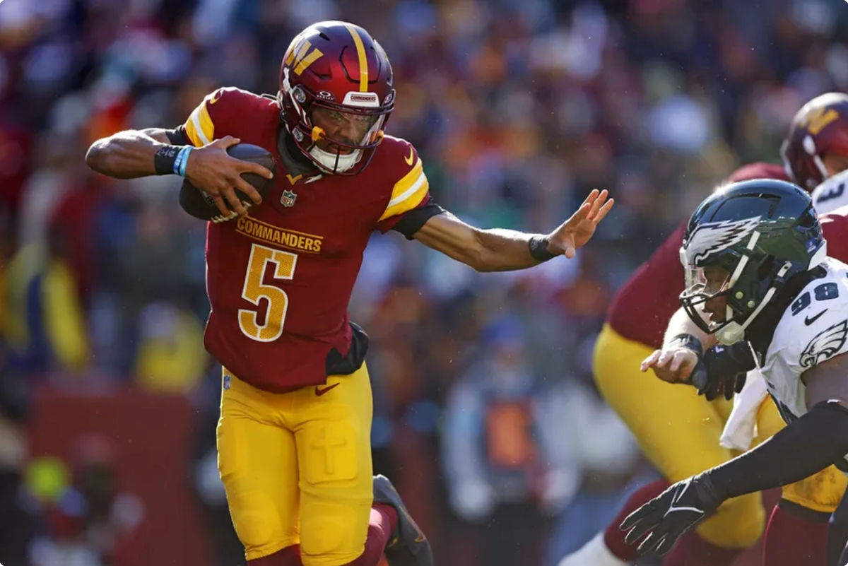 Dec 22, 2024; Landover, Maryland, USA; Washington Commanders quarterback Jayden Daniels (5) runs the ball against Philadelphia Eagles defensive tackle Jalen Carter (98) during the first quarter at Northwest Stadium. Mandatory Credit: Peter Casey-Imagn Images
