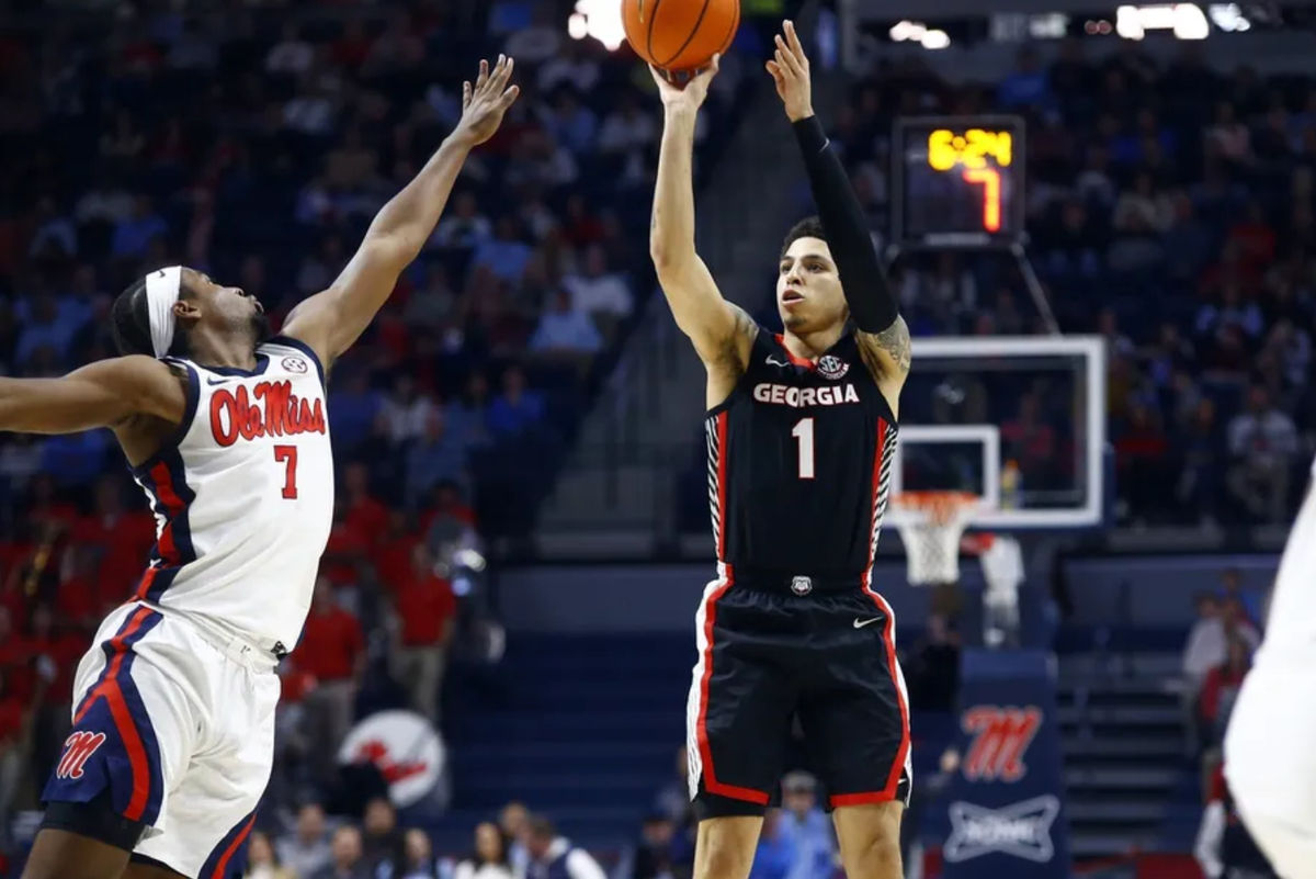 4 de janeiro de 2025; Oxford, Mississippi, EUA; O armador do Georgia Bulldogs, Dakota Leffew (1), arremessa para três enquanto o armador do Mississippi Rebels, Davon Barnes (7), defende durante o primeiro tempo no The Sandy e John Black Pavilion no Ole Miss. Crédito obrigatório: Petre Thomas-Imagn Images
