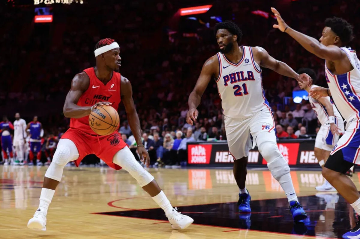 18 de noviembre de 2024; Miami, Florida, EE. UU.; El delantero de Miami Heat, Jimmy Butler (22), avanza hacia la canasta contra el pívot de los Philadelphia 76ers, Joel Embiid (21), y el escolta Kyle Lowry (7), durante el segundo cuarto en el Kaseya Center. Crédito obligatorio: Sam Navarro-Imagn Images