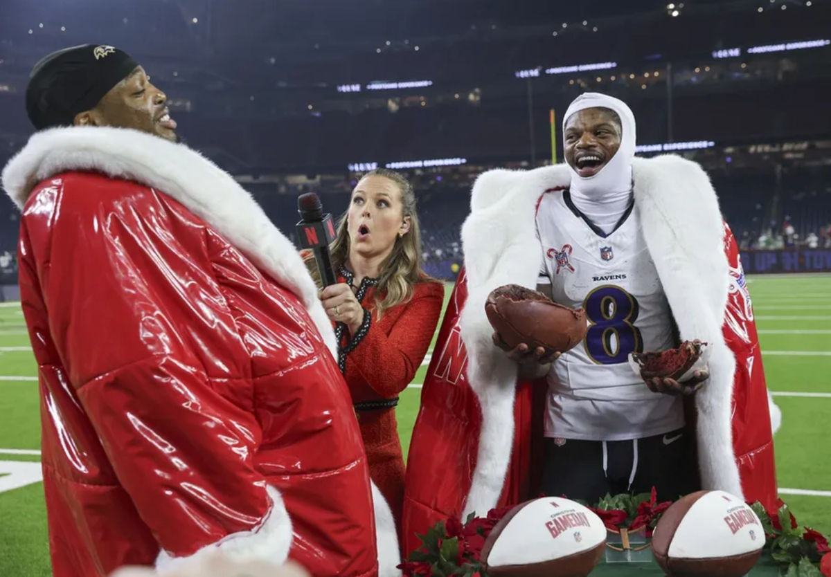 El mariscal de campo de los Baltimore Ravens, Lamar Jackson (8), y el corredor Derrick Henry (22) visten abrigos de Papá Noel mientras son entrevistados por el presentador de Netflix, Jamie Erdahl, después del partido contra los Houston Texans en el NRG Stadium. Crédito obligatorio: Troy Taormina-Imagn Images