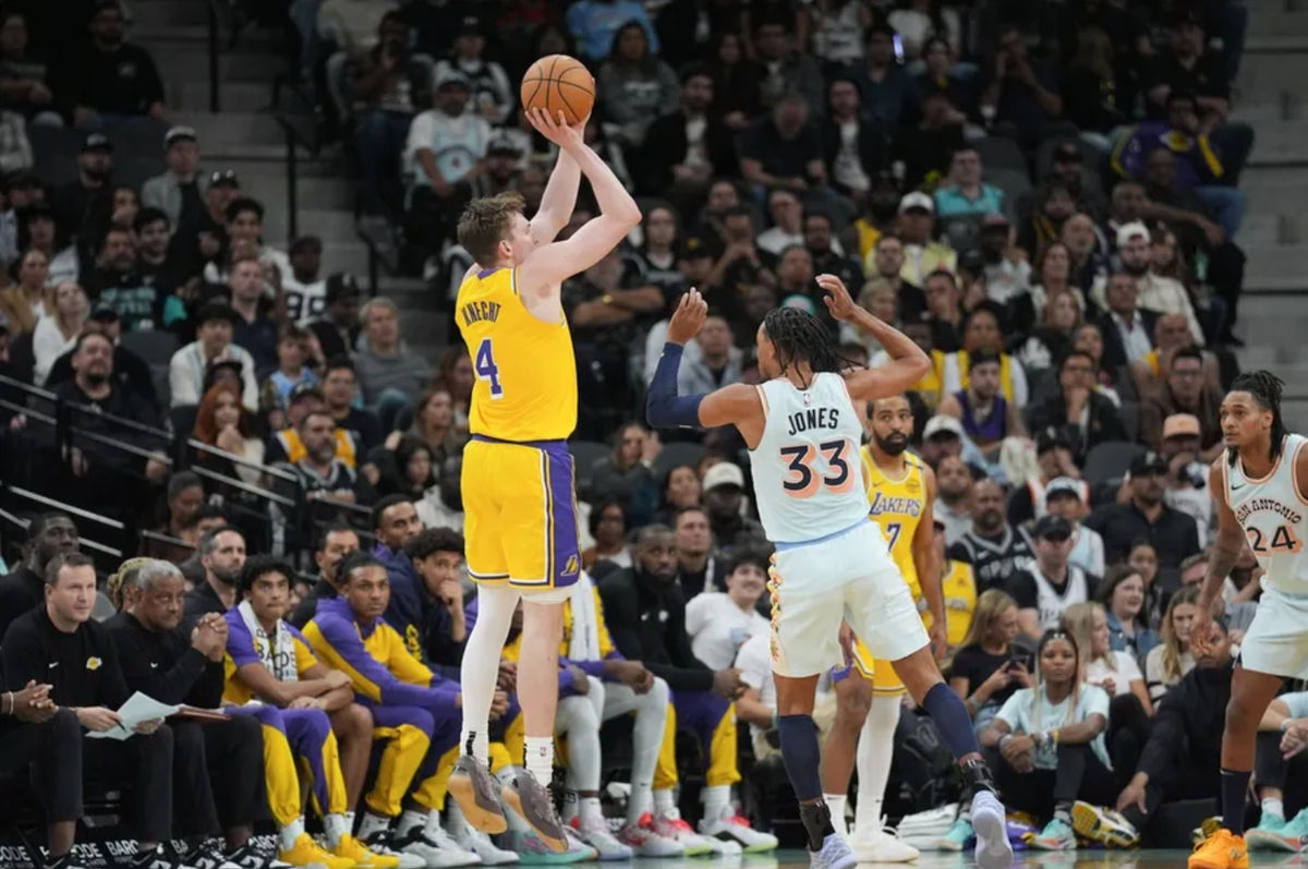 27 de noviembre de 2024; San Antonio, Texas, EE. UU.; El escolta de Los Angeles Lakers, Dalton Knecht (4), lanza sobre el escolta de San Antonio Spurs, Tre Jones (33), en la primera mitad en el Frost Bank Center. Crédito obligatorio: Daniel Dunn-Imagn Images