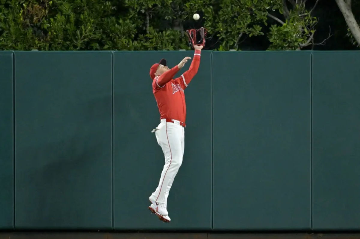 6 de abril de 2024; Anaheim, California, EE. UU.; El jardinero de los Angelinos de Los Ángeles, Mike Trout (27), realiza una atrapada de salto en la pared tras un elevado bateado por el jardinero de los Medias Rojas de Boston, Jarren Duran (16), en la octava entrada en el Angel Stadium. Crédito obligatorio: Jayne Kamin-Oncea-Imagn Images
