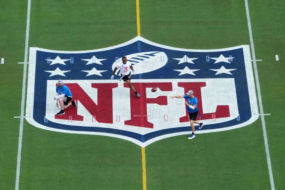 2 de febrero de 2025; Orlando, Florida, EE. UU.; Vista general del mariscal de campo de la NFC, Jared Goff, de los Detroit Lions (16), lanza el balón sobre el logotipo del escudo de la NFL en el mediocampo bajo la presión del safety de la AFC, Derwin James, de los Los Angeles Chargers (3), durante los juegos Pro Bowl 2025 en el Camping World Stadium. Crédito obligatorio: Kirby Lee-Imagn Images