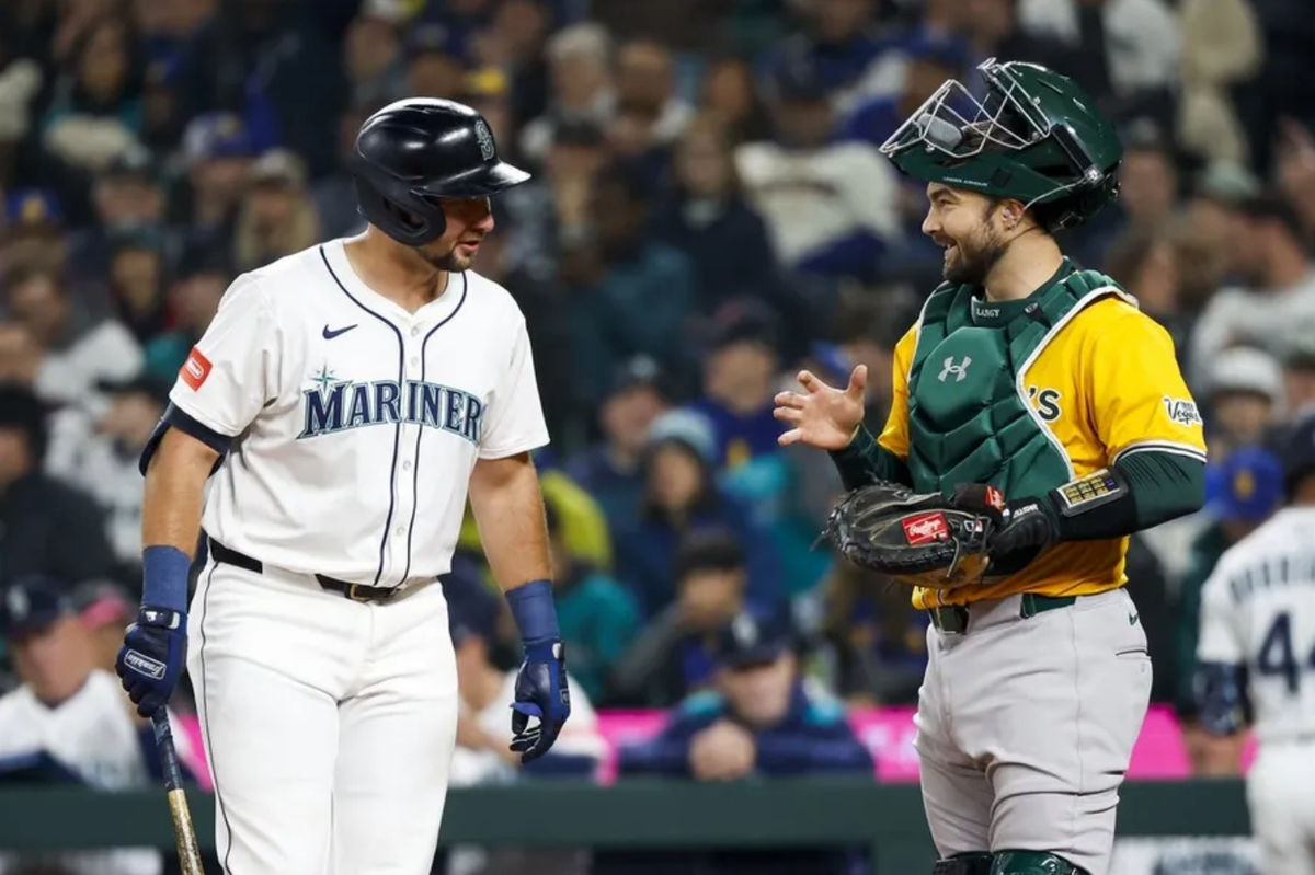 Mar 27, 2025; Seattle, Washington, USA; Athletics catcher Shea Langeliers (23) talks with catcher Cal Raleigh (29) during a first inning at-bat by Raleigh at T-Mobile Park. Mandatory Credit: Joe Nicholson-Imagn Images