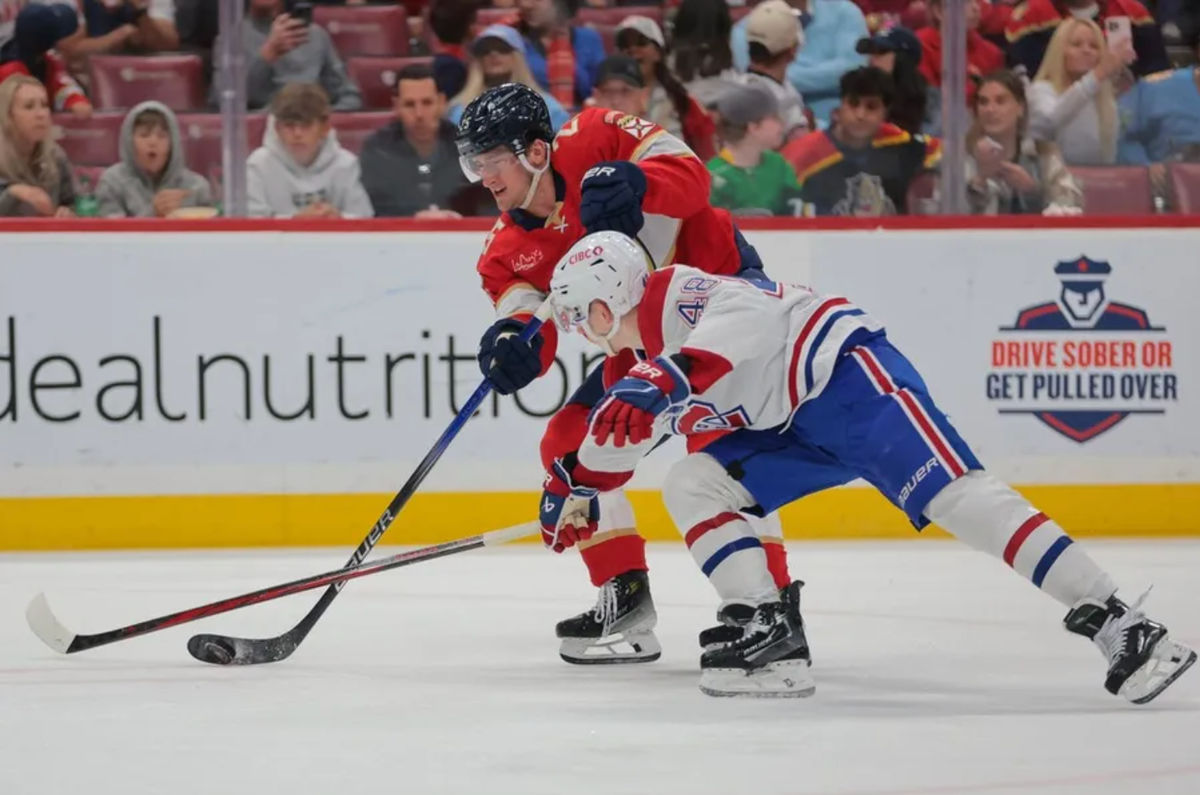 Mar 30, 2025; Sunrise, Florida, USA; Florida Panthers right wing Mackie Samoskevich (25) shoots the puck as Montreal Canadiens defenseman Lane Hutson (48) defends during the second period at Amerant Bank Arena. Mandatory Credit: Sam Navarro-Imagn Images