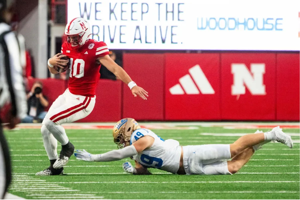 2 de novembro de 2024; Lincoln, Nebraska, EUA; O quarterback do Nebraska Cornhuskers, Heinrich Haarberg (10), corre para fora de campo contra o linebacker do UCLA Bruins, Carson Schwesinger (49), durante o quarto período no Memorial Stadium. Crédito obrigatório: Dylan Widger-Imagn Images
