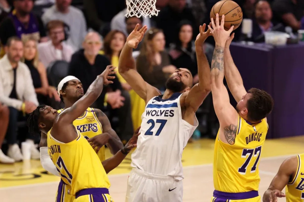 22 de abril de 2025; Los Ángeles, California, EE. UU.; El base de Los Angeles Lakers, Luka Doncic (77), captura un rebote contra el pívot de los Minnesota Timberwolves, Rudy Gobert (27), durante el primer cuarto del segundo partido de la primera ronda de los Playoffs de la NBA 2024 en el Crypto.com Arena. Crédito obligatorio: Kiyoshi Mio-Imagn Images.