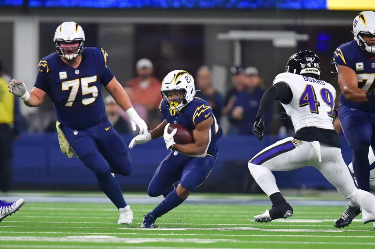 25 de noviembre de 2024; Inglewood, California, EE. UU.; El corredor de Los Angeles Chargers, J.K. Dobbins (27), corre con el balón contra los Baltimore Ravens durante la primera mitad en el SoFi Stadium. Crédito obligatorio: Gary A. Vasquez-Imagn Images