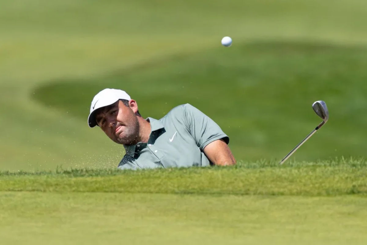 Jun 21, 2025; Cromwell, Connecticut, USA; Scottie Scheffler plays a shot from a bunker on the first hole during the third round of the Travelers Championship golf tournament. Mandatory Credit: Bill Streicher-Imagn Images