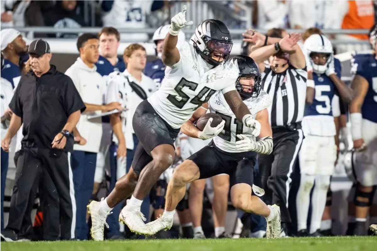 O defensive back do Oregon, Dillon Thieneman (à direita), agarra a interceptação da vitória enquanto o inside linebacker do Oregon, Jerry Mixon, comemora a vitória do Oregon Ducks sobre o Penn State Nittany Lions em 27 de setembro de 2025, no Beaver Stadium em University Park, Pensilvânia. FOTO: USA TODAY SPORTS IMAGENS