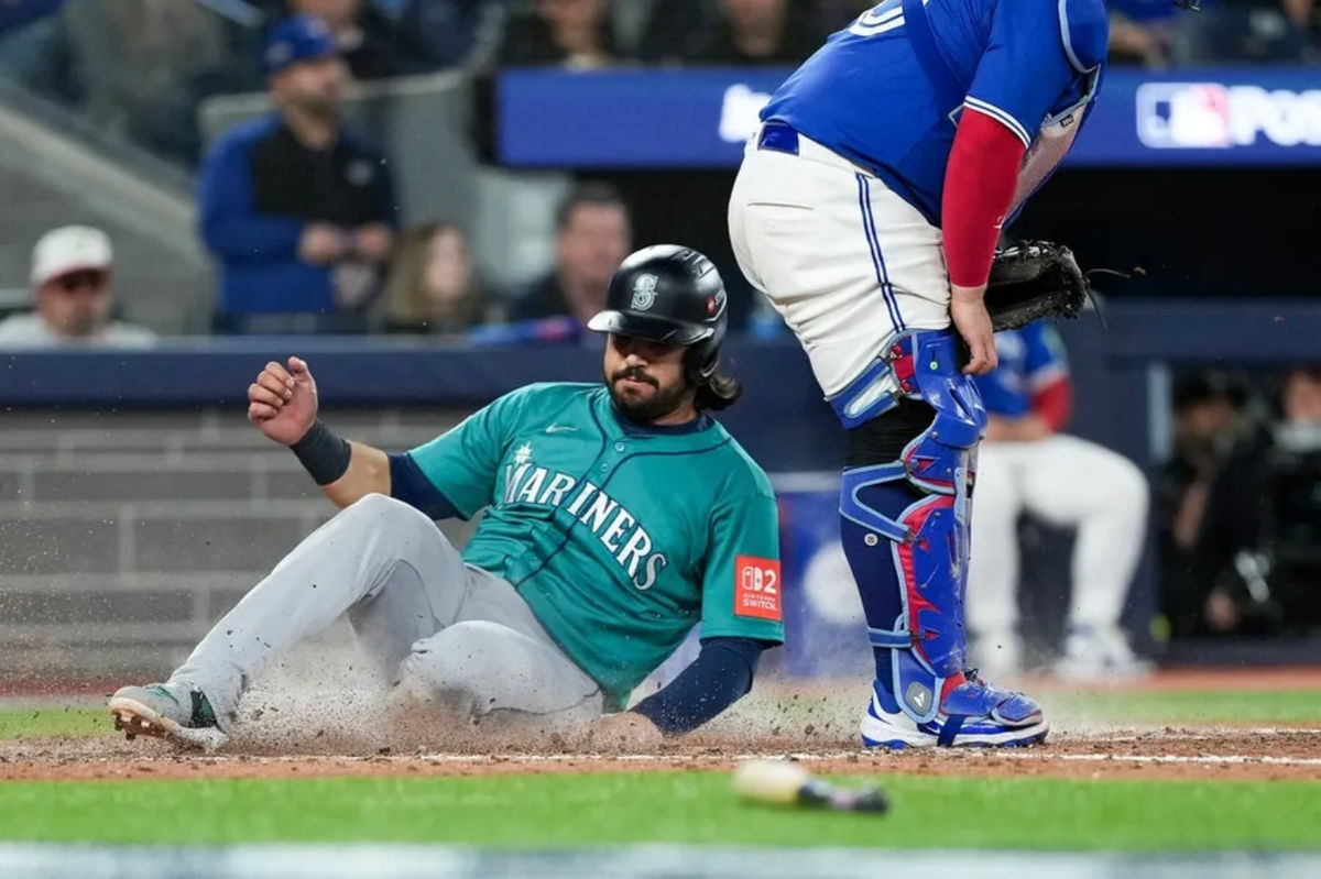 Oct 13, 2025; Toronto, Ontario, CAN; Seattle Mariners infielder Eugenio Suárez (28) scores on a sacrifice fly by in the seventh inning against the Toronto Blue Jays during game two of the ALCS round for the 2025 MLB playoffs at Rogers Centre. Mandatory Credit: Nick Turchiaro-Imagn Images