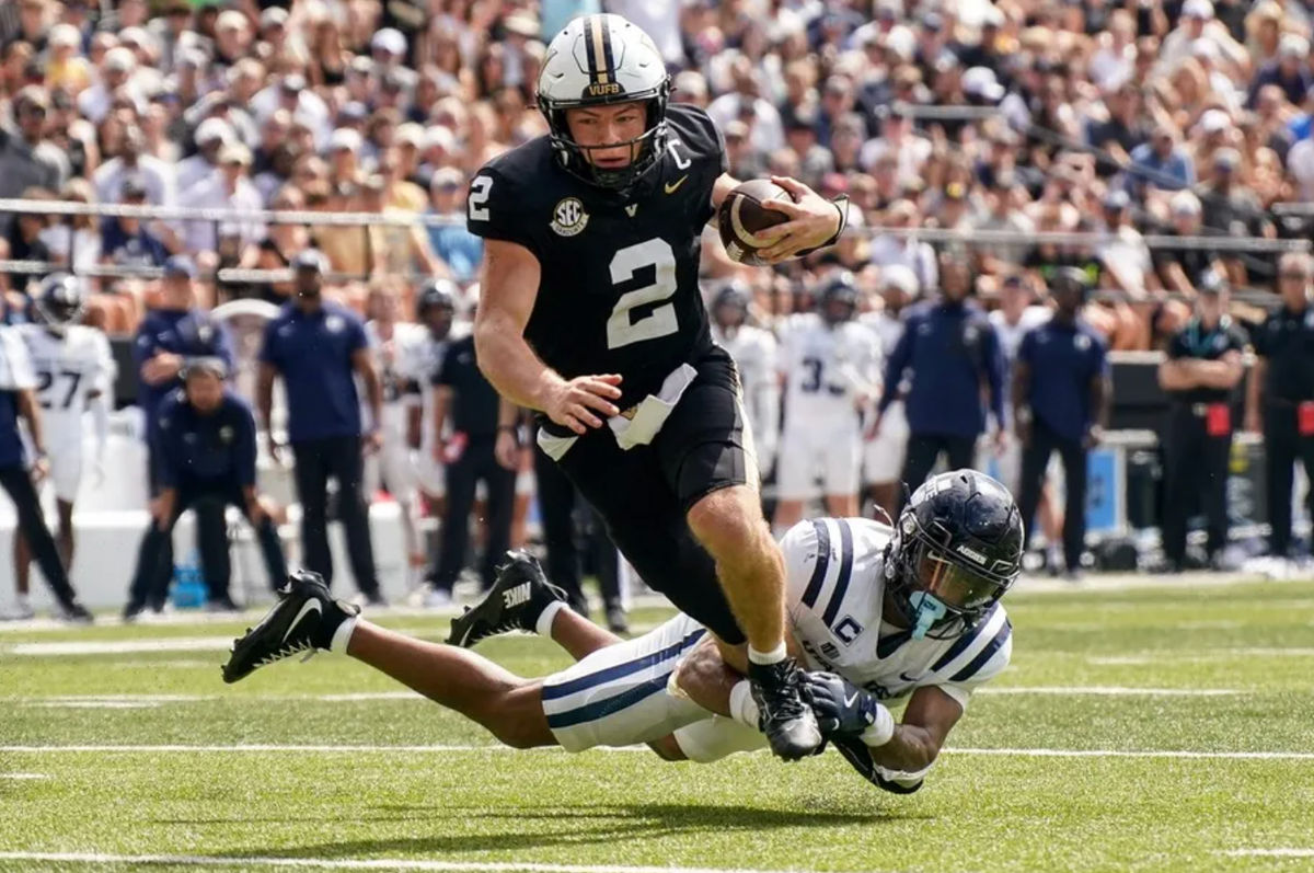 El mariscal de campo de Vanderbilt, Diego Pavia (2), anota un touchdown superando al esquinero de Utah State, Noah Avinger (1), durante el segundo cuarto en el FirstBank Stadium de Nashville, Tennessee, el sábado 27 de septiembre de 2025. FOTO: USA TODAY SPORTS IMAGES