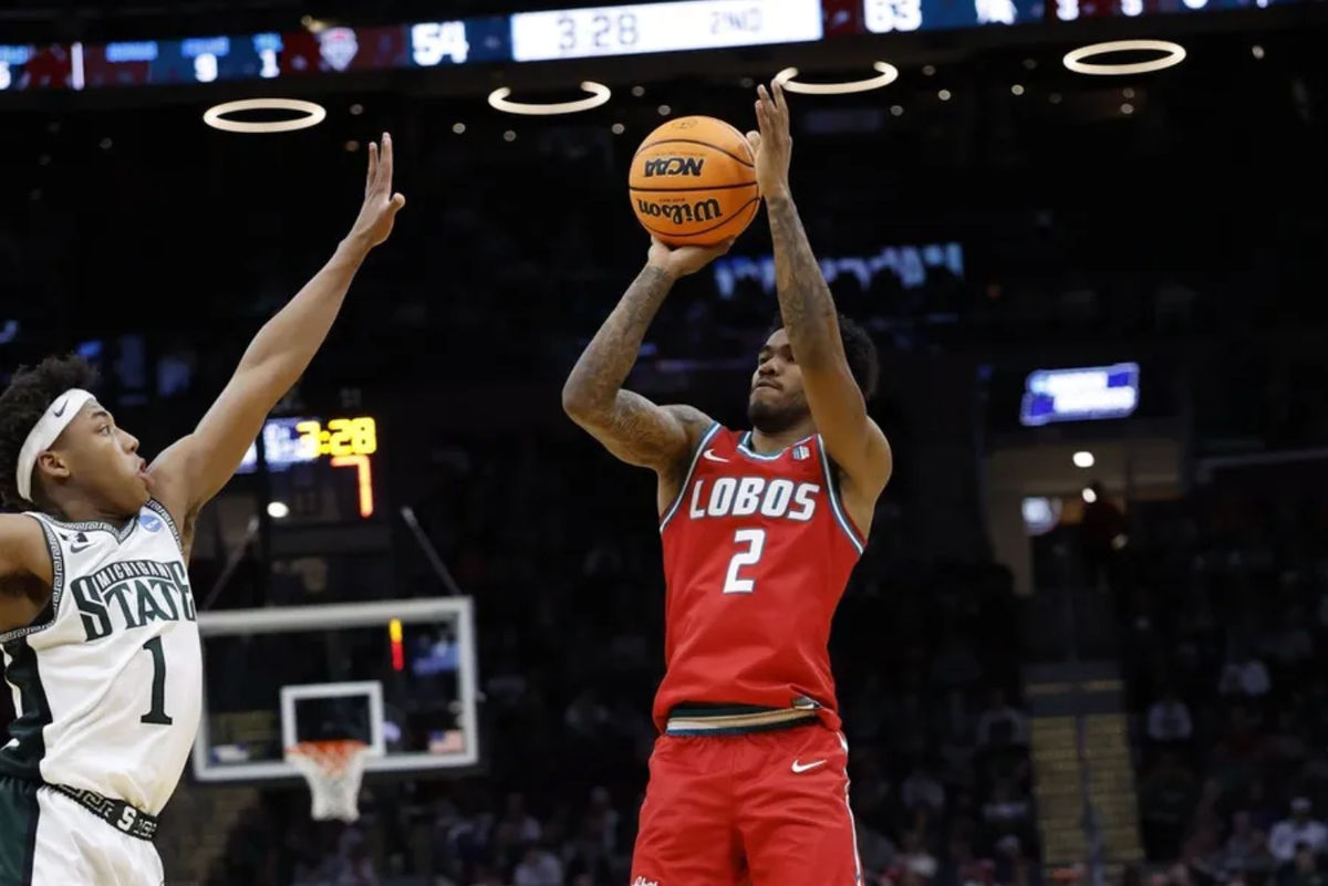 Mar 23, 2025; Cleveland, OH, USA; New Mexico Lobos guard Donovan Dent (2) shoots the ball over Michigan State Spartans guard Jeremy Fears Jr. (1) in the second half during the NCAA Tournament Second Round at Rocket Arena. Mandatory Credit: Rick Osentoski-Imagn Images