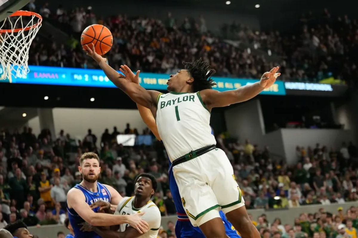 Feb 1, 2025; Waco, Texas, USA; Baylor Bears guard Robert Wright III (1) scores a layup against Kansas Jayhawks guard Dajuan Harris Jr. (3) during the second half at Paul and Alejandra Foster Pavilion. Mandatory Credit: Chris Jones-Imagn Images