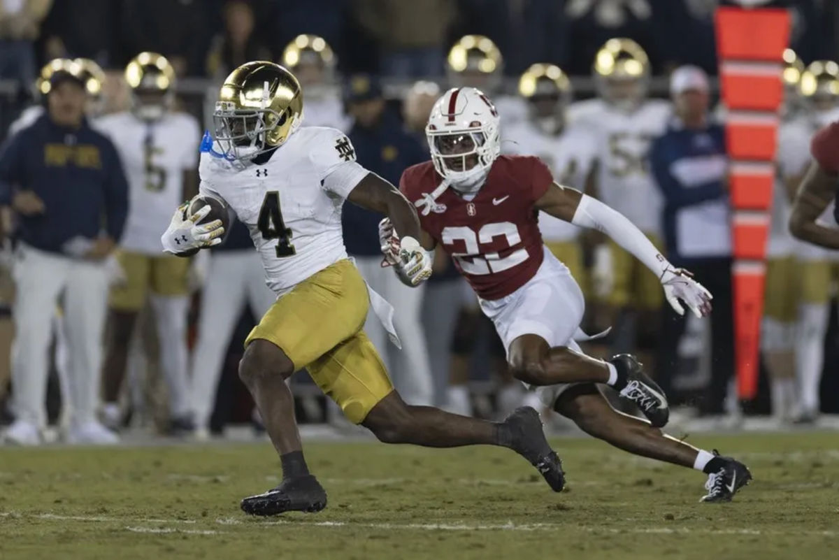 29 de noviembre de 2025; Stanford, California, EE. UU.; El corredor de Notre Dame Fighting Irish, Jeremiyah Love (4), corre con el balón durante el primer cuarto contra el safety de Stanford Cardinal, Che Ojarikre (22), en el Estadio Stanford. Crédito obligatorio: Stan Szeto-Imagn Images