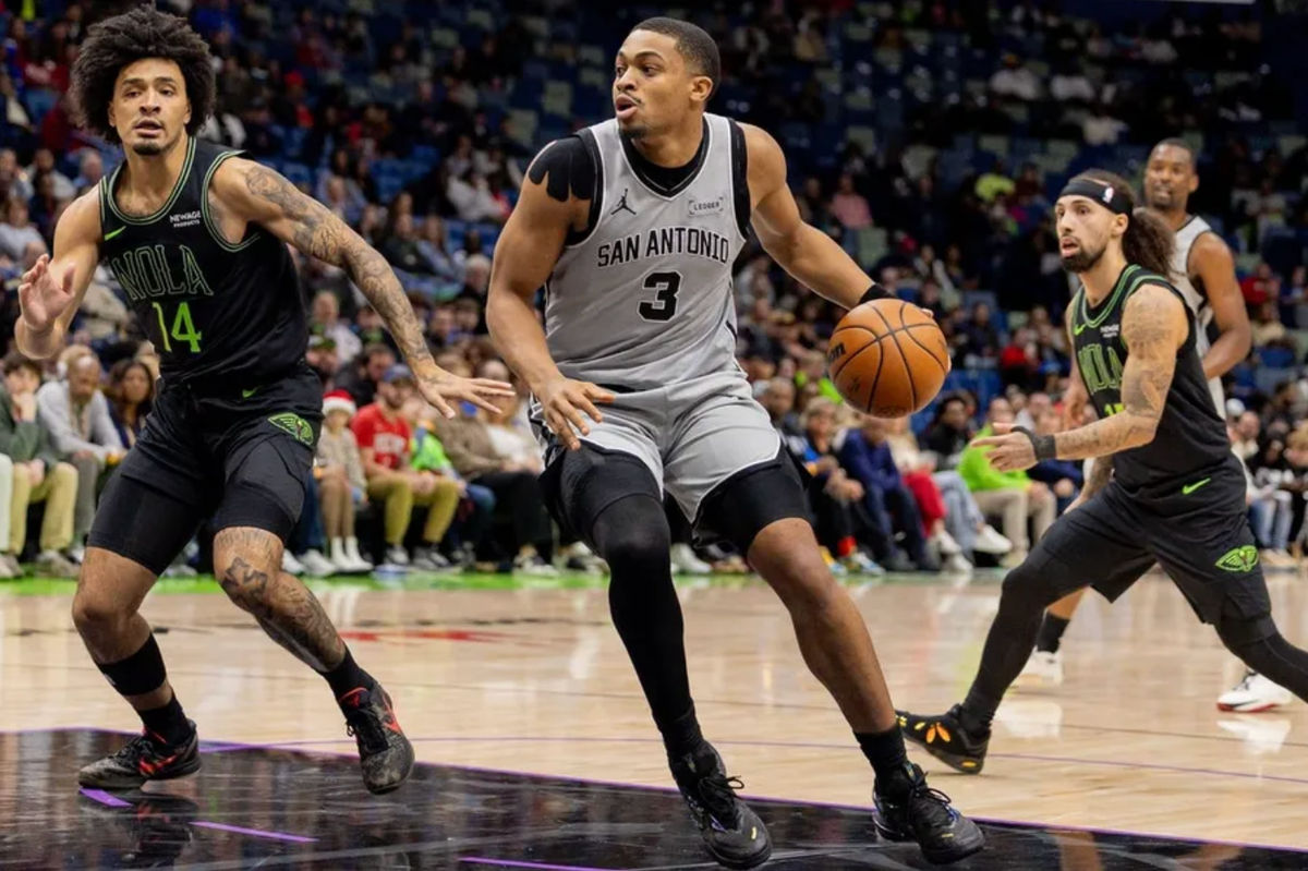 Dec 8, 2025; New Orleans, Louisiana, USA; San Antonio Spurs forward/guard Keldon Johnson (3) dribbles against New Orleans Pelicans guard/forward Micah Peavy (14) during the first half at Smoothie King Center. Mandatory Credit: Stephen Lew-Imagn Images
