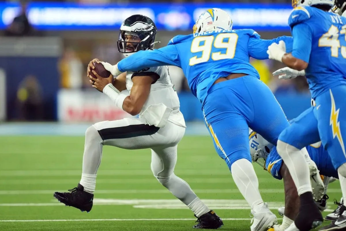 Dec 8, 2025; Inglewood, California, USA; Los Angeles Chargers defensive tackle Jamaree Caldwell (99) tackles Philadelphia Eagles quarterback Jalen Hurts (1) in the first half at SoFi Stadium. Mandatory Credit: Kirby Lee-Imagn Images