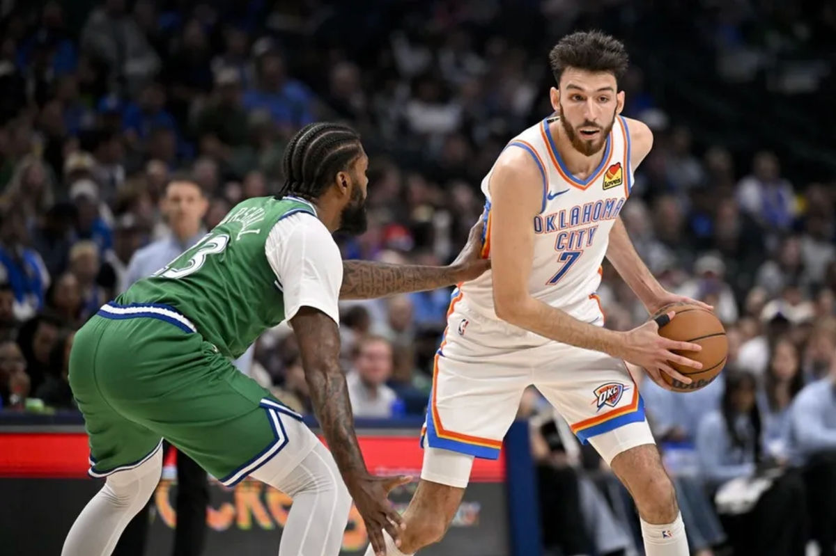 27 de outubro de 2025; Dallas, Texas, EUA; O pivô do Oklahoma City Thunder, Chet Holmgren (7), tenta passar a bola pelo ala do Dallas Mavericks, Naji Marshall (13), durante o segundo quarto no American Airlines Center. Crédito obrigatório: Jerome Miron-Imagn Images