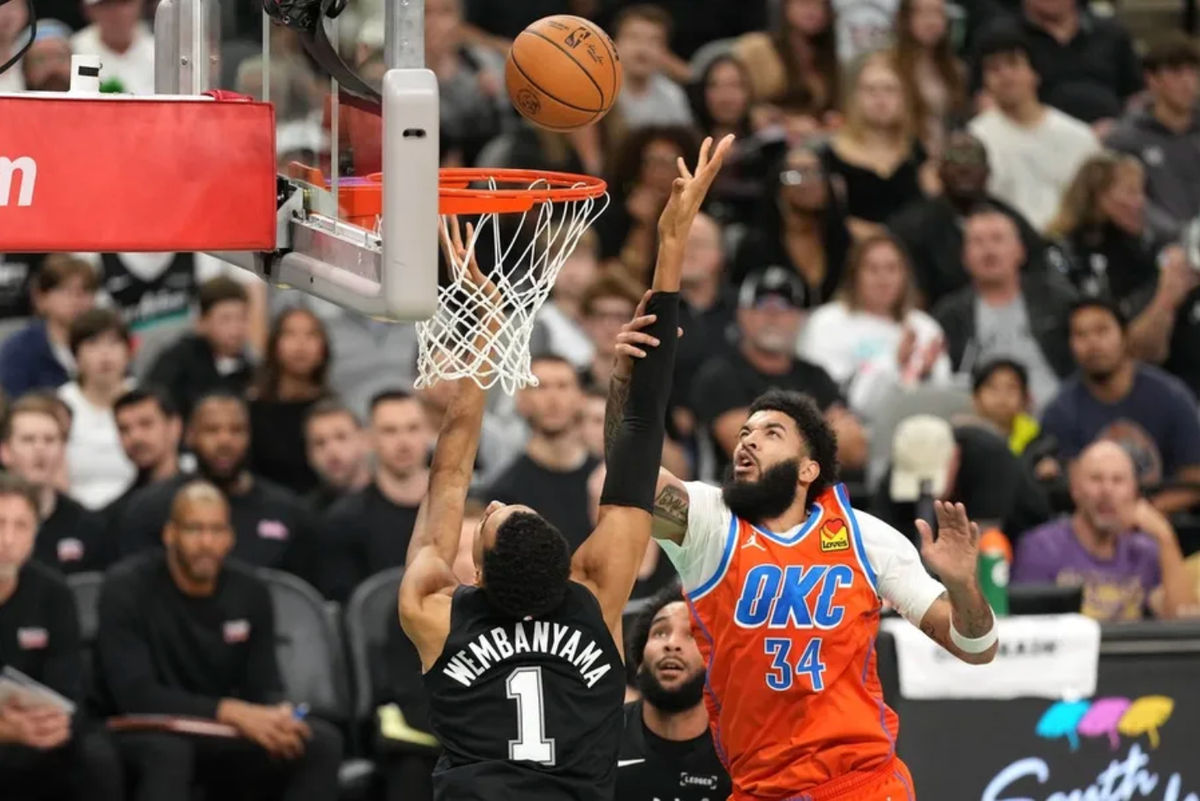 Dec 23, 2025; San Antonio, Texas, USA; San Antonio Spurs forward Victor Wembanyama (1) shoots while being fouled by Oklahoma City Thunder guard Kenrich Williams (34) during the first half at Frost Bank Center. Mandatory Credit: Scott Wachter-Imagn Images