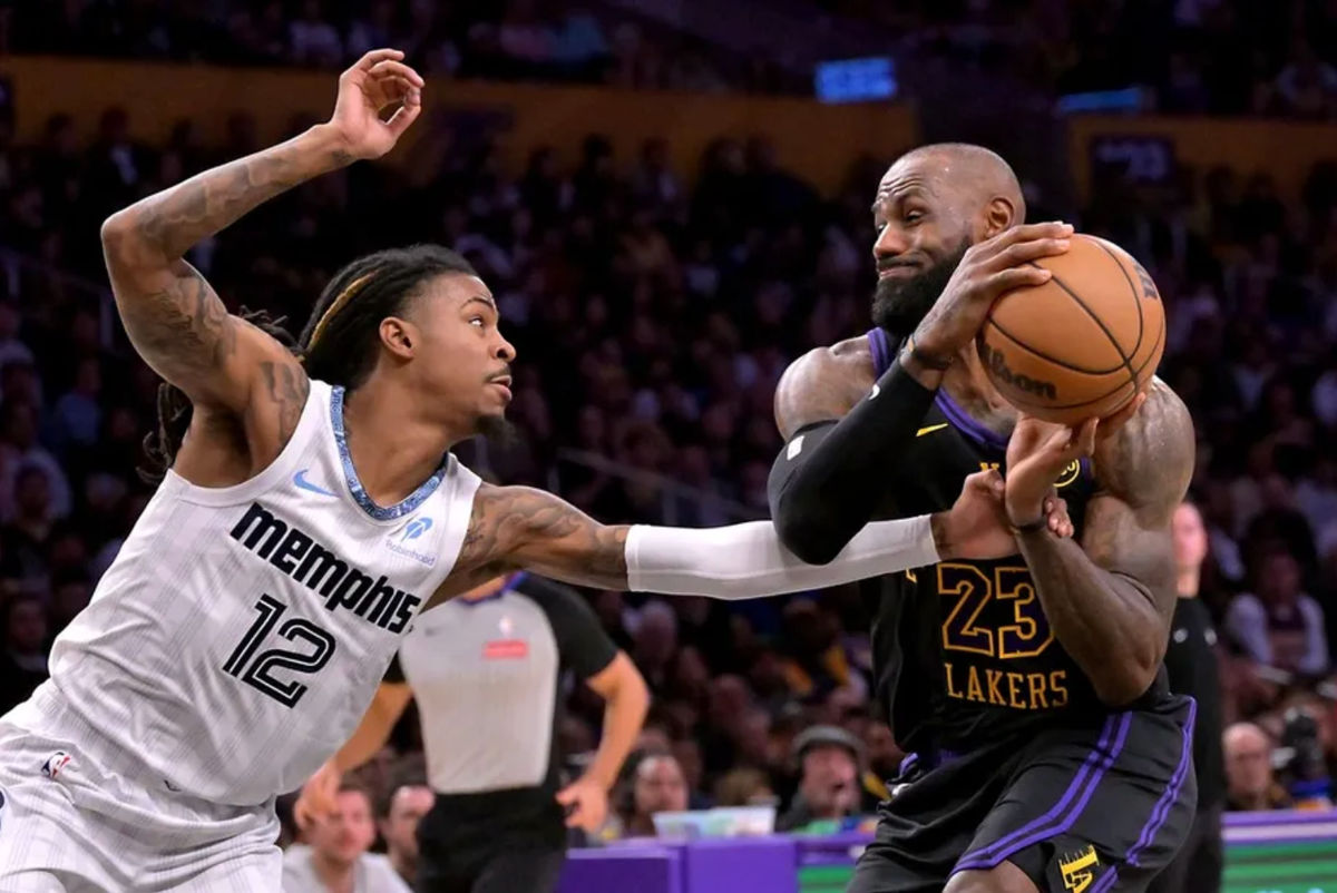 Jan 2, 2026; Los Angeles, California, USA; Memphis Grizzlies guard Ja Morant (12) defends Los Angeles Lakers forward Lebron James (23) as he drives to the basket during the first half at Crypto.com Arena. Mandatory Credit: Jayne Kamin-Oncea-Imagn Images